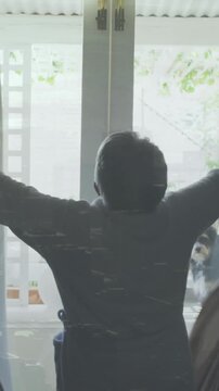 Opening curtains, person revealing bright outdoor patio with dog in background