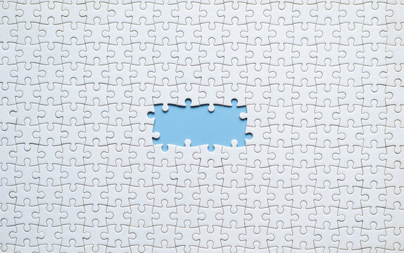 White jigsaw puzzle with missing piece on blue background for health and wellness concept