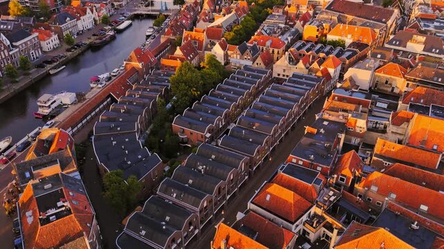 Golden-hour aerial of Zwolle, Netherlands, showing the historic center with dense red-roofed buildings, narrow streets and a canal winding through the old urban core.
