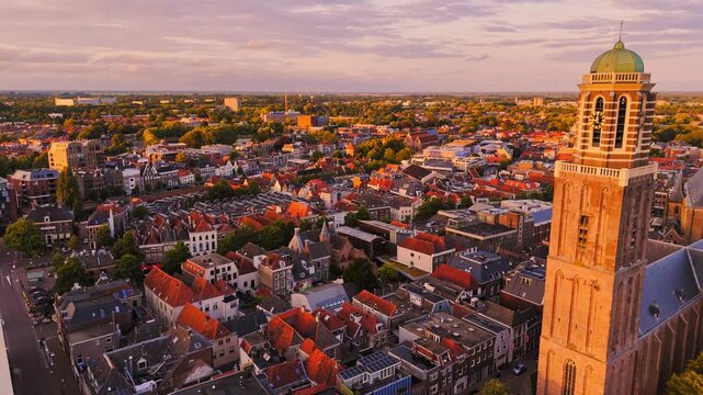 Golden-hour aerial of Zwolle, Netherlands, featuring the iconic Peperbus tower and Basilica of Our Lady rising above dense historic rooftops and the old city center.