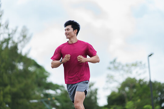 Asian man jogging outdoors enjoying active healthy lifestyle