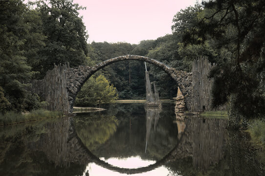 Famous Rakotzbruecke Devils Bridge with perfect circular reflection in a scenic park