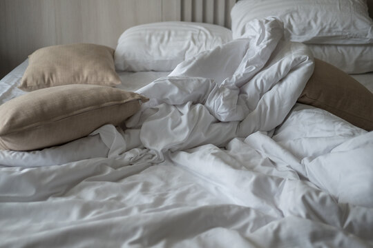 Soft pillows on comfortable bed. Empty bedroom, pillow, blanket and white linen after wake up.