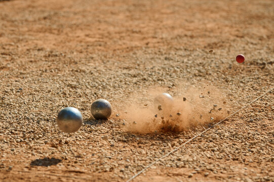 Petanque Boule Impact Splash Dust Cloud and Red Cochonnet Action Shot