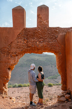 Couple admiring view through Mirleft castle archway in Morocco