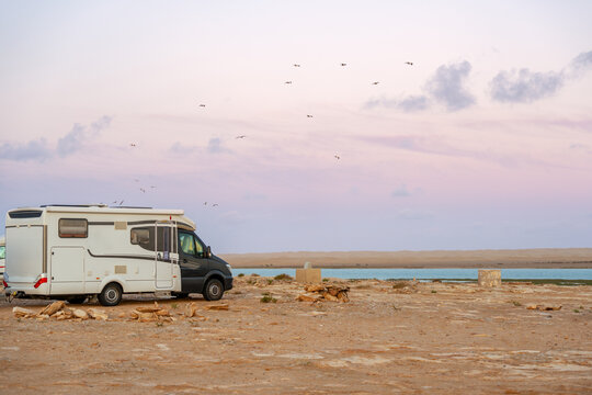Motorhome parked by river in Morocco Khnifiss National Park at sunset