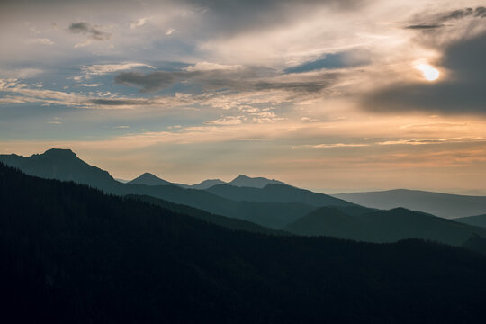 Dramatic mountain range silhouettes at sunset with dramatic clouds