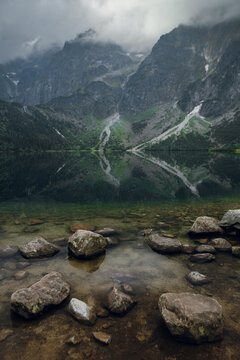 Morskie Oko lake reflecting dramatic Tatra mountains under cloudy sky