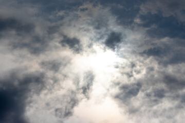 Obraz premium Bright sunlight breaking through dramatic dark storm clouds scattered across the sky.