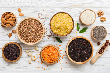 Obraz premium Various superfoods in smal bowl on colored background. Superfood as rice, chia, quinoa, lentils, nuts, sesame seeds, almonds. top view copy space