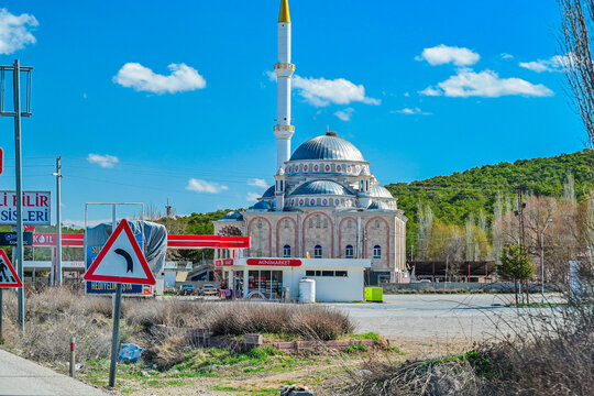 Mosque with a minaret behind a gas station and a road sign on a country road near Pamukkale, modern Ottoman architecture, Denizli Province, Aegean Region, T&uuml;rkiye 25.03.2025