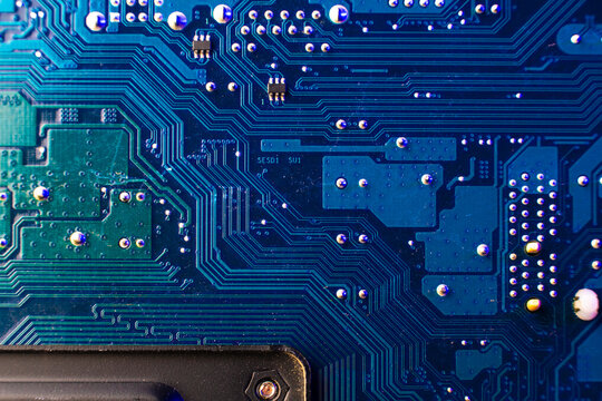 Detailed macro photography of tiny surface mount electronic components and traces on a blue server network board.