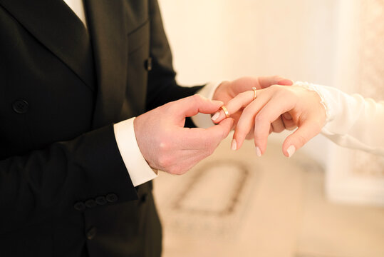 Groom placing a wedding ring on his bride&rsquo;s finger during a Muslim nikah wedding ceremony. Symbolic moment of marriage, commitment and union in an Islamic wedding celebration.