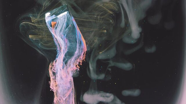 Rectangular translucent block submerging into dark liquid while releasing dense pastel ink plume that trails downward and fans into frothy pink and blue ribbons