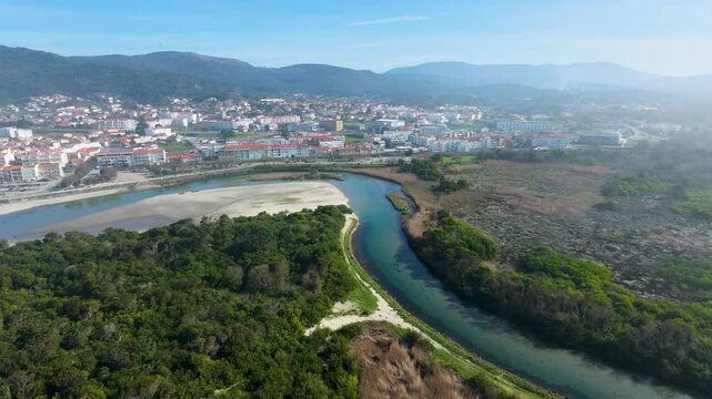 Aerial drone view of the Rio &Acirc;ncora flowing into the Atlantic Ocean at Vila Praia de &Acirc;ncora, with golden sand, coastline and stunning scenery.