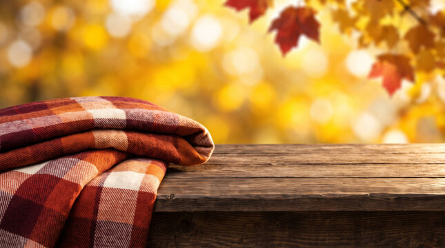 Autumn picnic blanket background with warm plaid fabric resting rustic wooden bench and golden foliage. Cosy vintage plaid fabric pattern. abstract chequered texture check, gingham tablecloth, fall