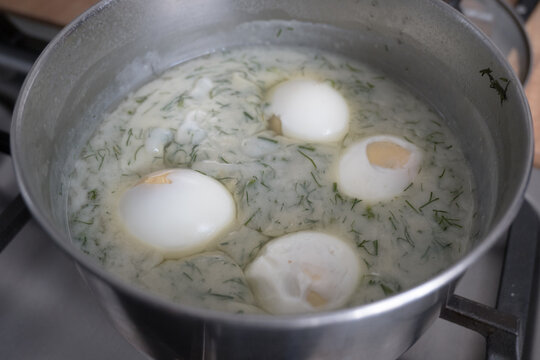 Cooking dill sauce with eggs in a pot.

