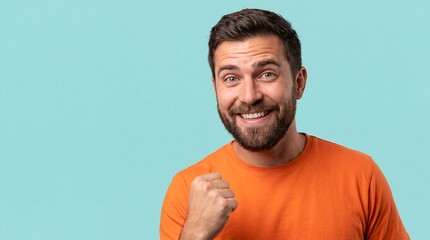 Naklejka premium Adult white man victorious smile raised fist cyan solid background An adult White man raises one fist with a broad victorious smile for achievement motivation and completion campaigns