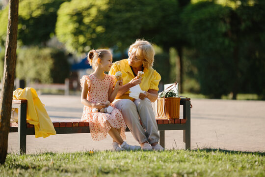 Grandmother and granddaughter enjoying ice cream in park