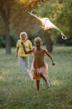 Granddaughter flying kite with grandmother in park