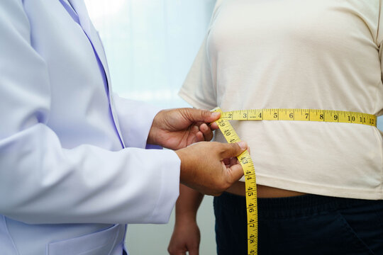 Asian woman with fat belly big size overweight and obesity with measure tape.