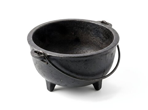 A weathered black cast iron cauldron with a sturdy handle and three legs isolated on a white background for rustic kitchen cooking and decor
