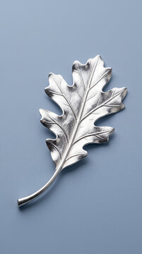 Metallic oak leaf ornament on a blue background, symbolizing nature, autumn, and elegance, suitable for decorative or conceptual use