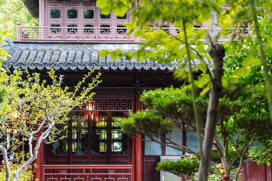 Traditional Chinese pavilion with glowing lanterns in Yu Garden surrounded by lush greenery in Shanghai.