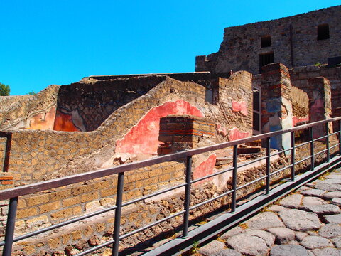 Stone paved ancient Roman street beside excavated Herculaneum ruins