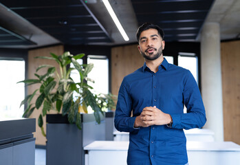 Business professional in modern office standing and speaking confidently to camera © WavebreakMediaMicro