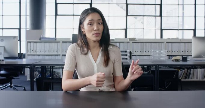 Close up of people talking to the camera, businesswoman at desk, gesturing with hand in office