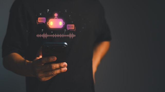 Man using smartphone with glowing AI chatbot hologram. Artificial intelligence voice recognition technology concept for smart digital communication and virtual assistant business.