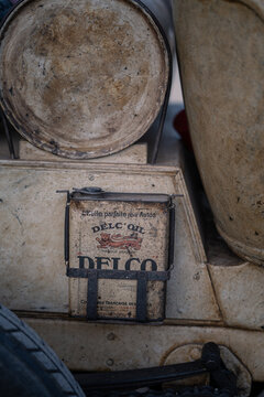 Litomysl, Czech Republic - July 8, 2026: Vintage Delco oil can mounted on a historic 1908 Peugeot Type 88 racing car. Close-up detail of authentic pre-war automobiles and retro fuel tank at a classic 