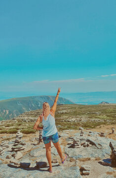 happy young woman on the top of a mountain, Serra de Estrela, the roof of Portugal, flipping a peace sign 
