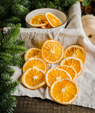 Dried orange slices and fir branches on linen cloth. Selective focus.