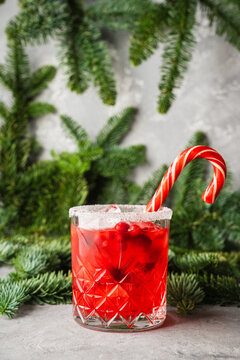 Red christmas cocktail with cranberry juice on the fir branches background. Christmas mood. Selective focus. 