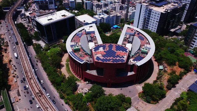 Metro train moving in front of TCS Deccan Park building with traffic flow and Maximus 2B building at hitec city, madhapur, hyderabad, telangana, india. day time, static shot, drone shot, 4k.
