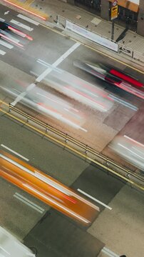 Vehicles including a black car and a white van move through a bustling city street with crosswalks and traffic signs visible. Time-lapse, Seoul, South Korea