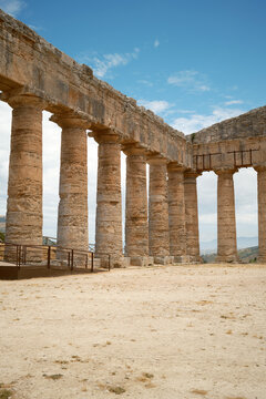 Vertical interior view of long Doric colonnade meeting corner entablature in Segesta, Sicily, Italy