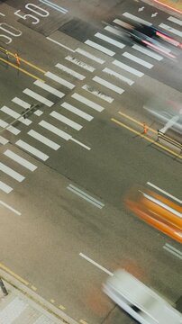 Urban street view capturing vehicles in motion across a crosswalk with clear lane markings and traffic cones visible. Time-lapse, Seoul, South Korea