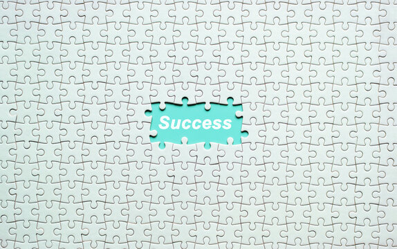 White jigsaw puzzle with Success text on green background