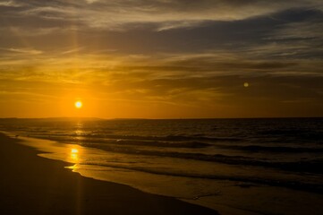 Obraz premium Sunrise on tropical island sea beach panorama, calm ocean sunset landscape, soft pink sky, peaceful morning dawn panoramic view, yellow sun reflection, blue water waves, summer holidays, vacation