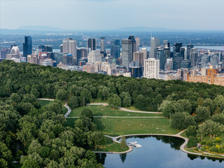 Fototapeta premium Montreal downtown skyline from Mount Royal with park, lake and greenery in summer, Quebec, Canada. g.
