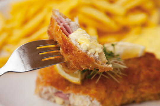 Cordon bleu with potato fries and sauce hollandaise, close up