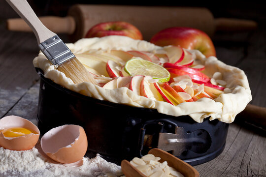 Raw apple pie in cake pan and ingredients