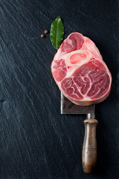 Raw beef shank with bay leaves and allspice on cleaver