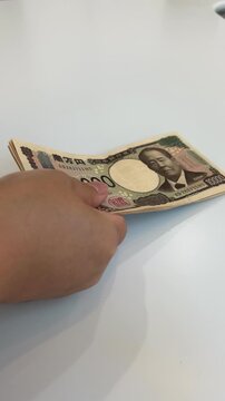 札束を差し出す手元