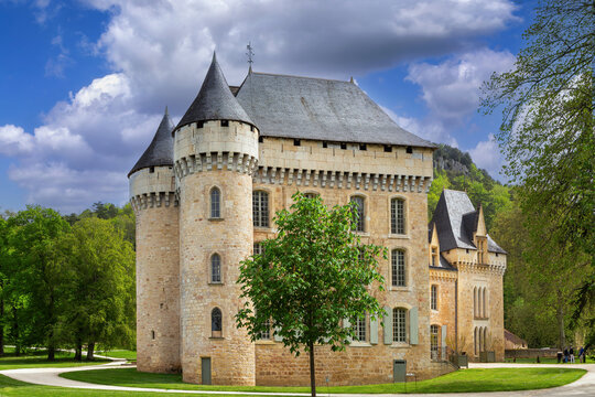 Chateau de Campagne in France. Historical medieval stone castle under partly cloudy sky