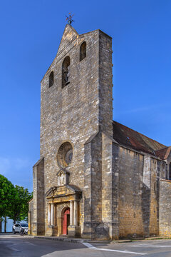 Church of Notre-Dame in Domme, France, facade view. Historical stone religious architecture under clear blue sky