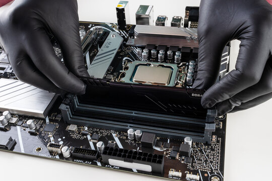 The female hands install the ddr4 RAM module in the motherboard socket close-up